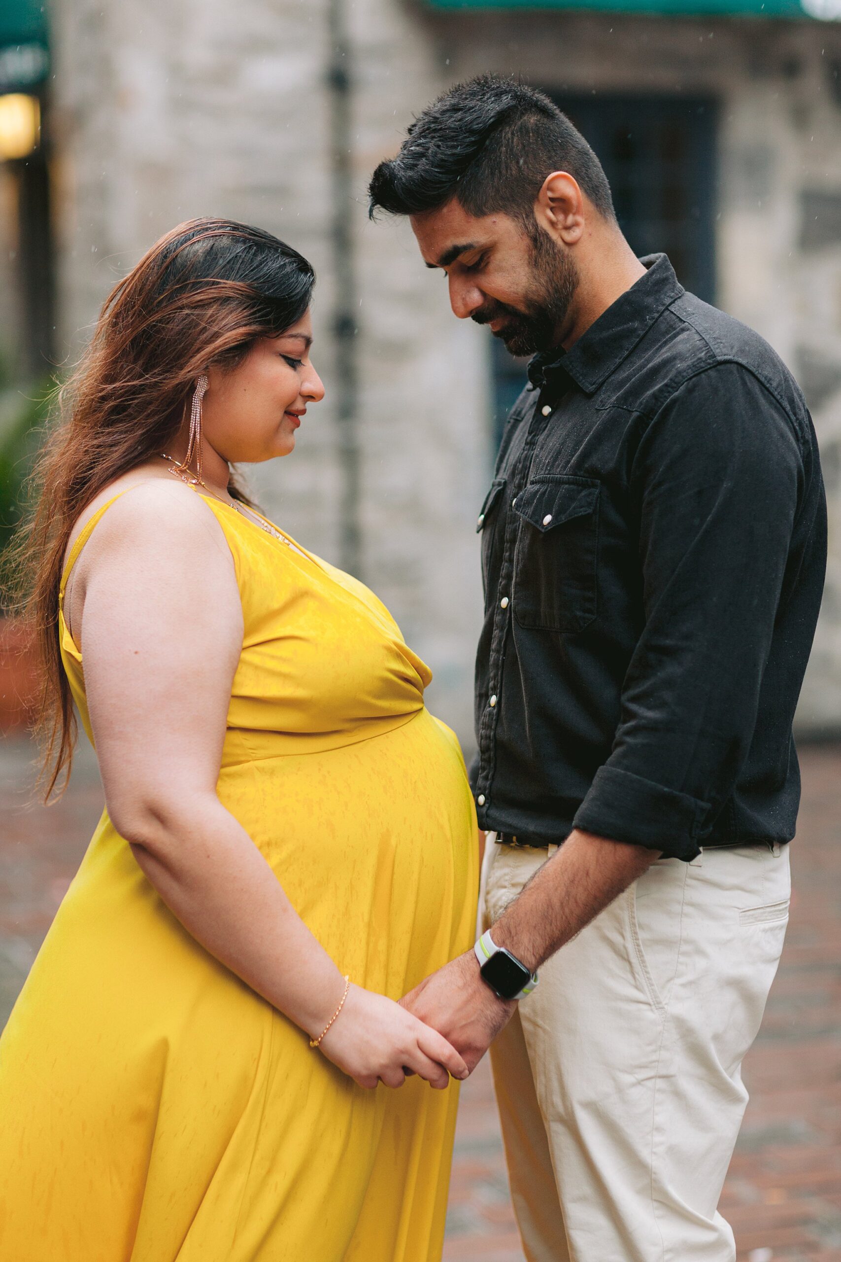 Romantic maternity session featuring a couple in love amidst the unique architecture of Old Port, Montreal.